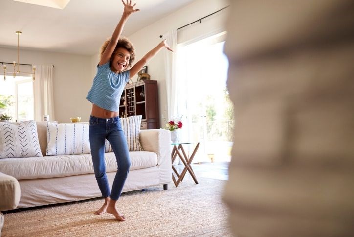 Happy girl dancing in front of the TV